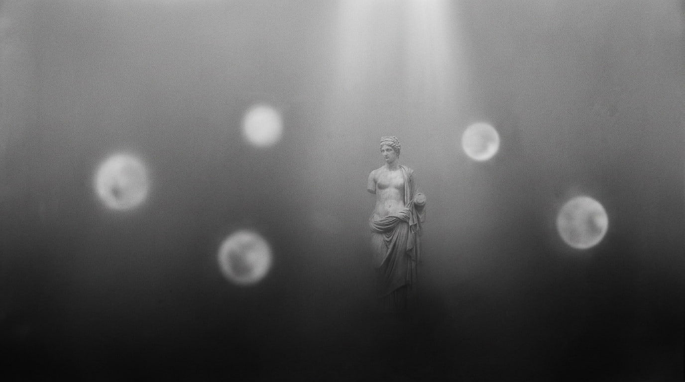 A classical figure held within a quiet field of light